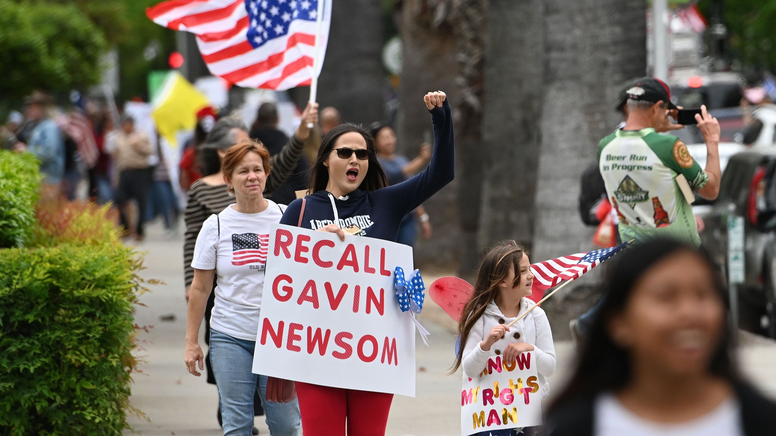 A woman shouts with a sign calling for the removal of California Gov. Gavin Newsom as hundreds of people gather to protest the lockdown in spite of shelter-in-place rules still being in effect at California's state capitol building in Sacramento, California on April 20, 2020. (JOSH EDELSON/AFP via Getty Images)