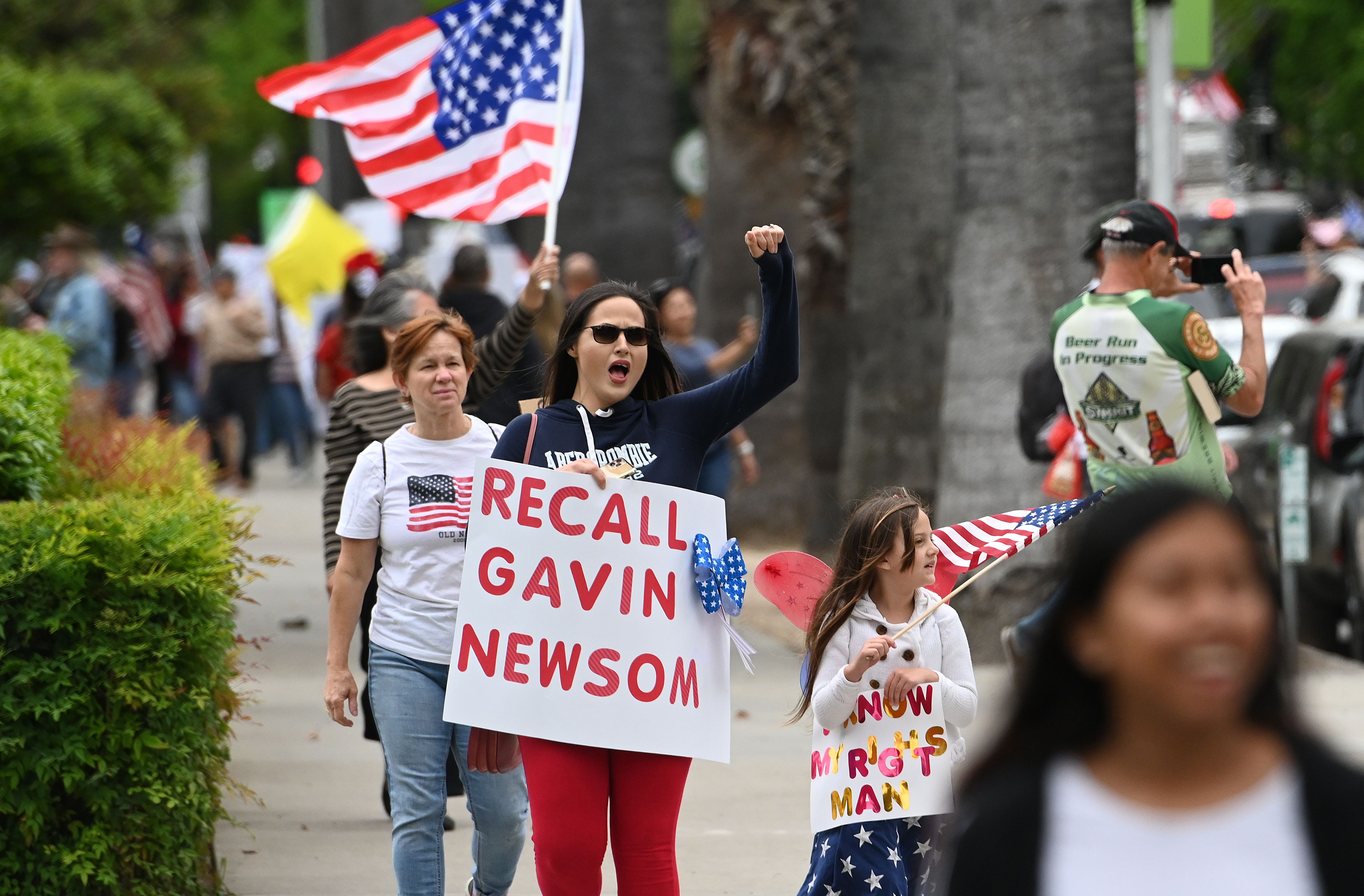 A woman shouts with a sign calling for the removal of California Gov. Gavin Newsom as hundreds of people gather to protest the lockdown in spite of shelter-in-place rules still being in effect at California's state capitol building in Sacramento, California on April 20, 2020. (JOSH EDELSON/AFP via Getty Images)