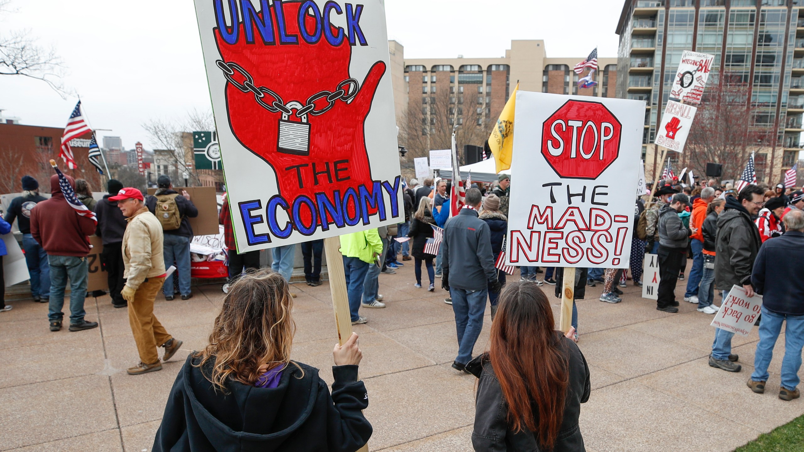 People hold signs during a protest against the coronavirus shutdown in front of the State Capitol in Madison, Wisconsin, on April 24, 2020. (KAMIL KRZACZYNSKI/AFP via Getty Images)