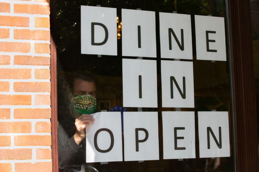 Barry Lennon, Operating Partner of J. Christopher, hangs up signs to to promote dine in service now available in the J. Christopher restaurant on April 27, 2020 in Brookhaven, Georgia. (Jessica McGowan/Getty Images)