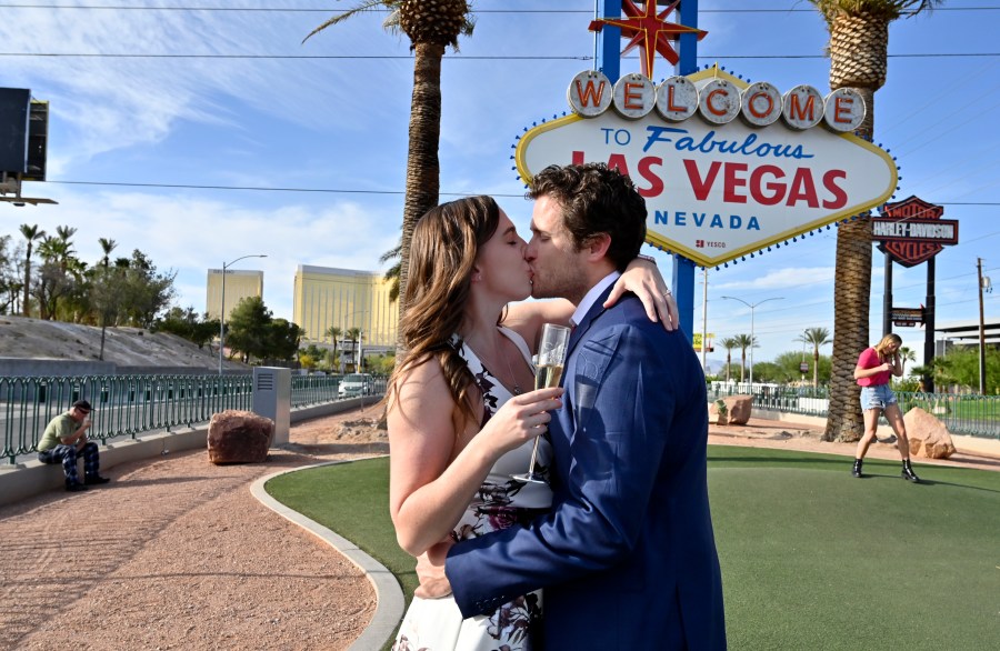 Las Vegas residents Elizabeth Billington, left, and Kenneth Quirk kiss as they celebrate what would have been their wedding day at the Welcome to Las Vegas sign on April 25, 2020. (David Becker / AFP / Getty Images)