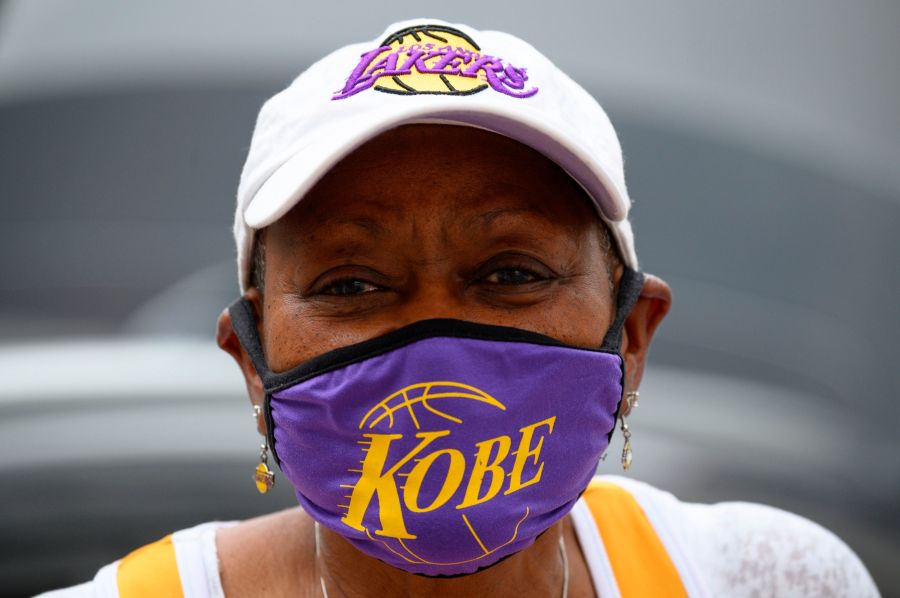 Carrie Harris Allen sells face masks, including the Kobe Bryant style she is wearing, in downtown Los Angeles on April 30, 2020. (Credit: Robyn Beck / AFP / Getty Images)