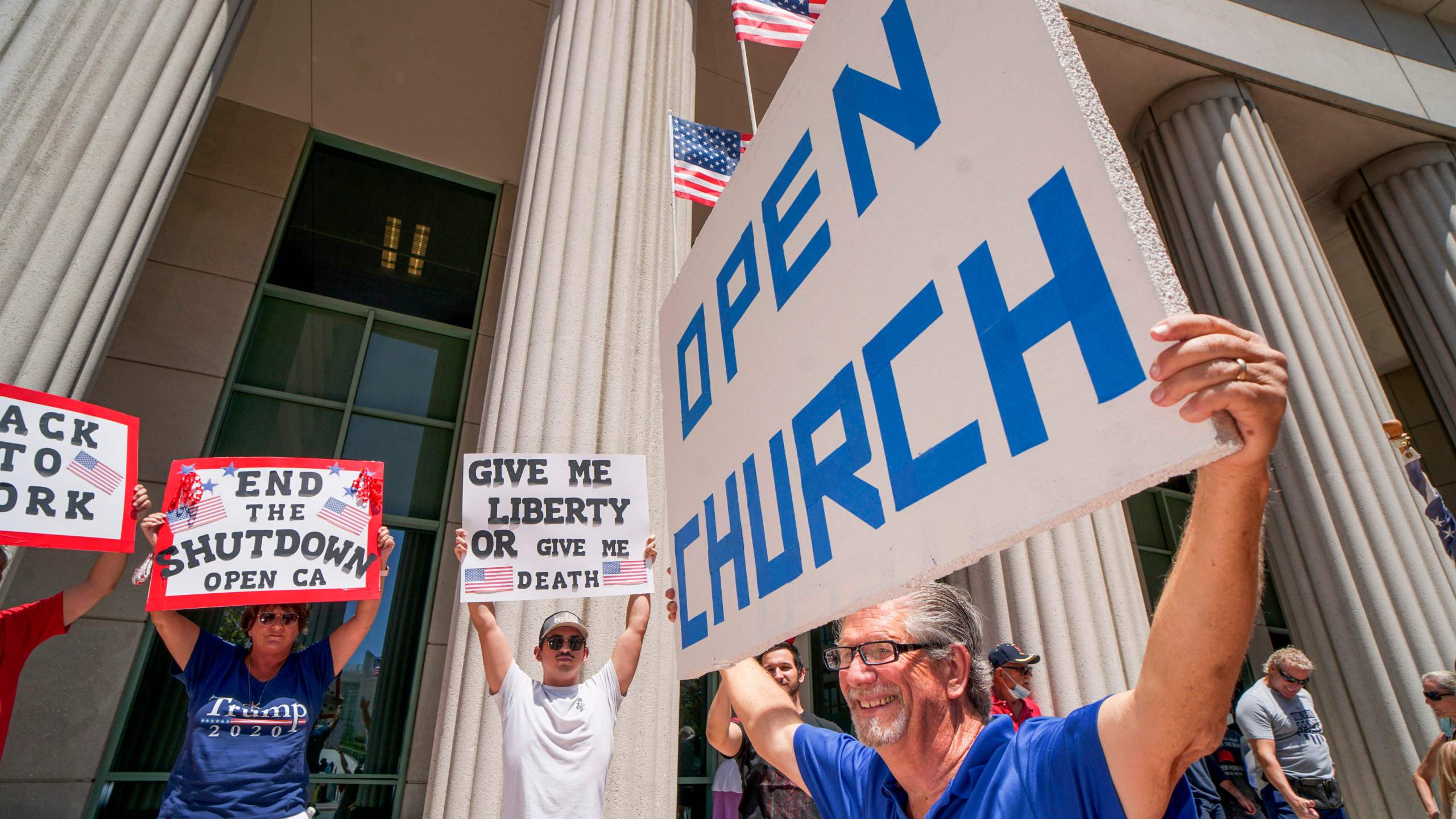 Demonstrators hold signs demanding their church to reopen during a rally to re-open California on May 1, 2020, in San Diego. (SANDY HUFFAKER/AFP via Getty Images)