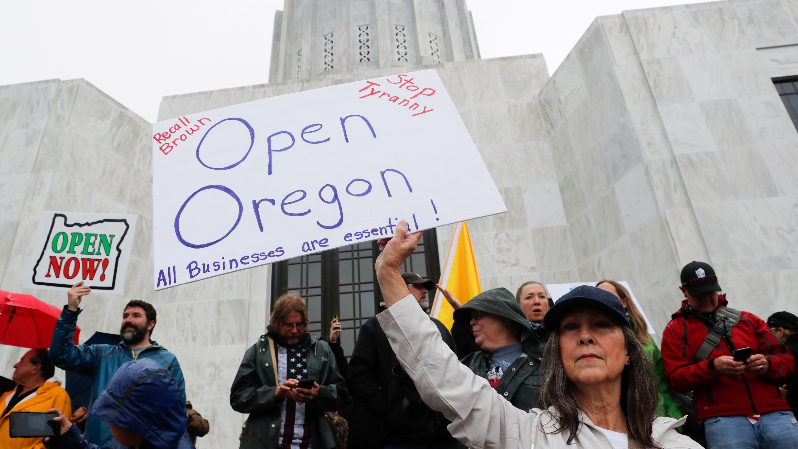 A woman holds a sign saying on the steps of the state capitol at the ReOpen Oregon Rally on May 2, 2020 in Salem, Oregon. (Terray Sylvester/Getty Images)