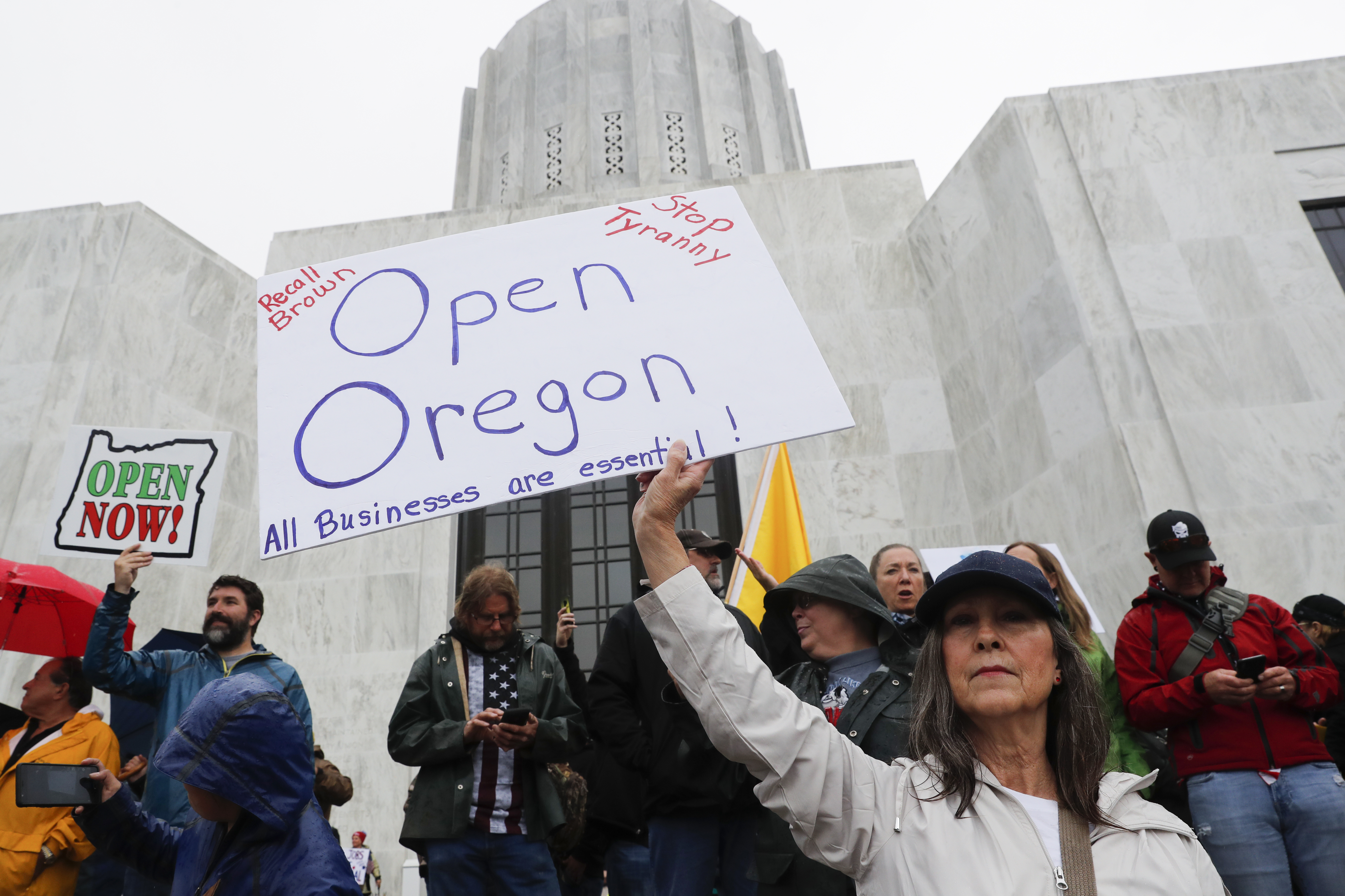 A woman holds a sign saying on the steps of the state capitol at the ReOpen Oregon Rally on May 2, 2020 in Salem, Oregon. (Terray Sylvester/Getty Images)