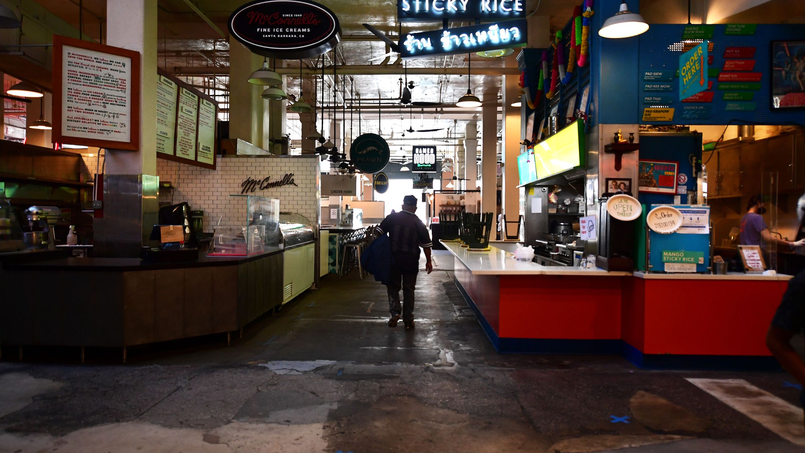 Some restaurants close as other remain open for takeout, observing new social distancing rules, with blue tape marked on the floor, at what would normally be a crowded lunctime scene at the Grand Central Market in Los Angeles, California on May 4, 2020. (FREDERIC J. BROWN/AFP via Getty Images)