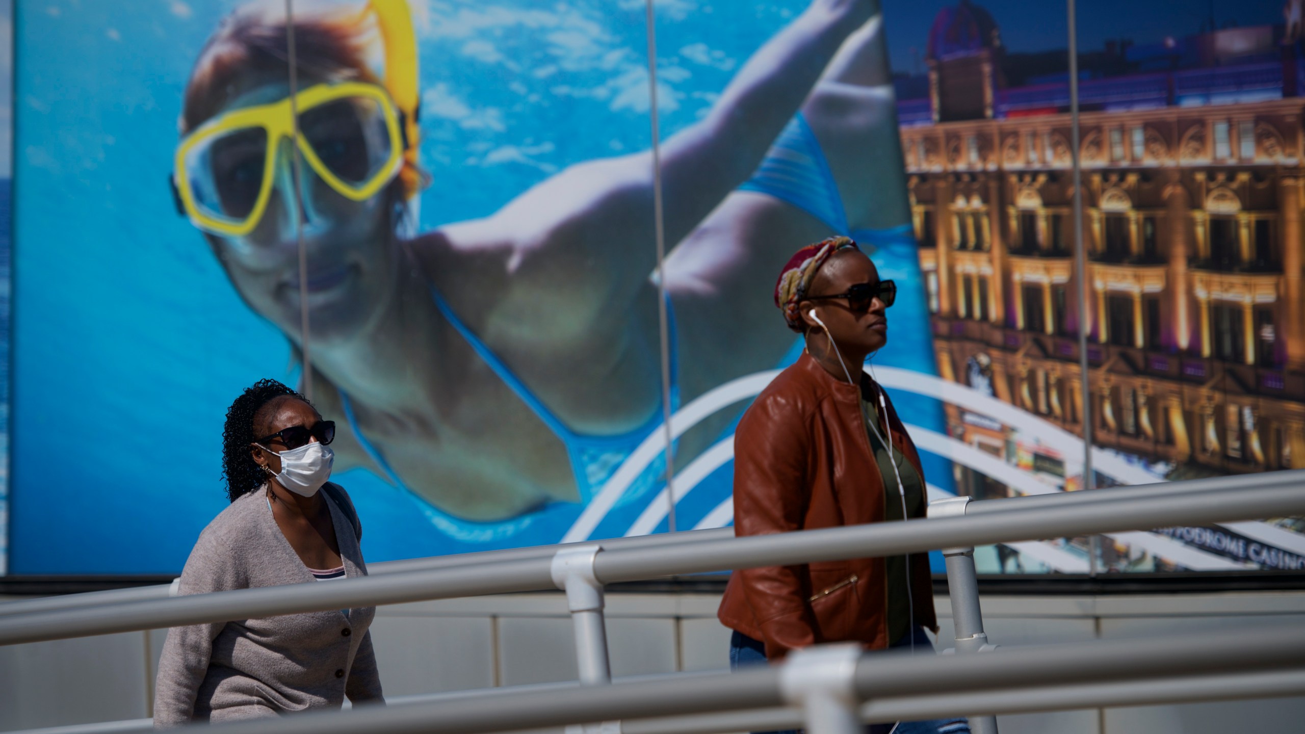 A pedestrian wears a mask while walking past a casino scuba diving poster during the coronavirus pandemic on May 7, 2020, in Atlantic City, New Jersey. (Mark Makela/Getty Images)