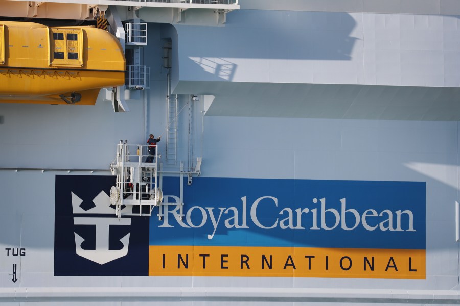 A worker paints the side of the Royal Caribbean Symphony of the Seas cruise ship, which is the world's largest passenger liner, as it is docked at Port Miami after returning to port from a Eastern Caribbean cruise as the world grapples with the coronavirus outbreak on March 14, 2020 in Miami, Florida. (Joe Raedle/Getty Images)