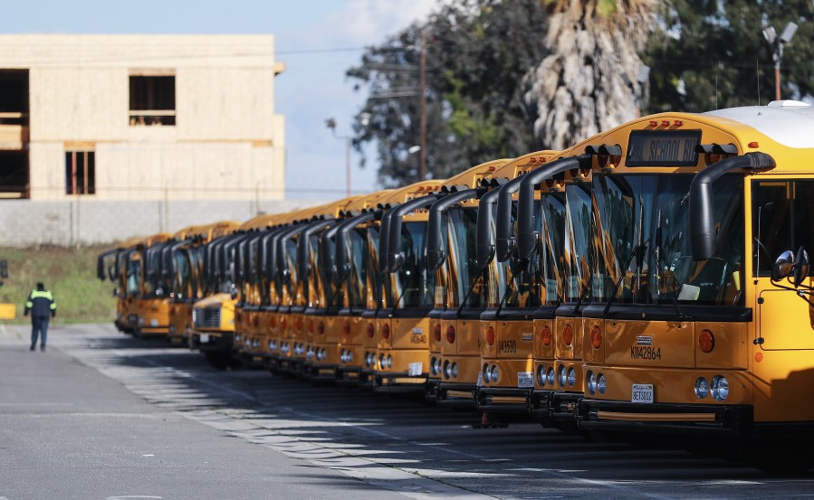 School buses are seen parked in a lot while schools schools stay closed in response to the coronavirus outbreak, on March 17, 2020, in Gardena. (Mario Tama/Getty Images)