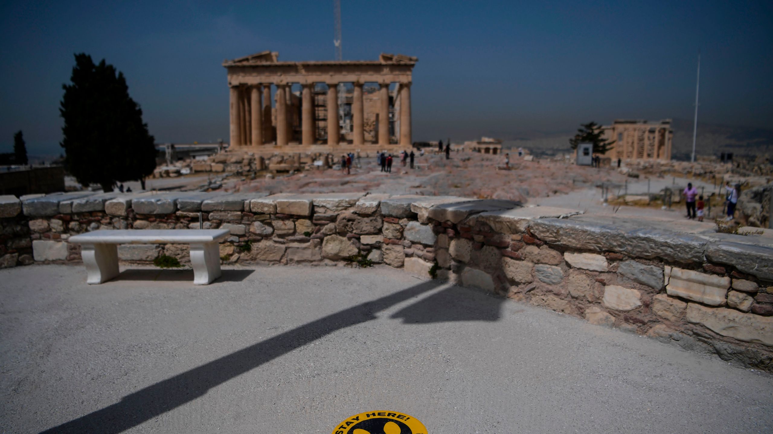 A picture taken on May 18, 2020 shows a sticker marking social distance on the ground in front of the Parthenon temple on the archeological site of the Acropolis in Athens amid the pandemic of the novel coronavirus. (Aris MESSINIS / Getty Images via AFP)