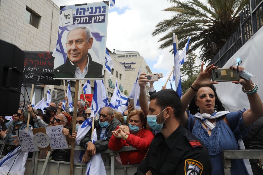 Israeli supporters hold flags and placards during a rally in support of Prime Minister Benjamin Netanyahu outside the district court of Jerusalem on May 24, 2020. (MENAHEM KAHANA/AFP via Getty Images)