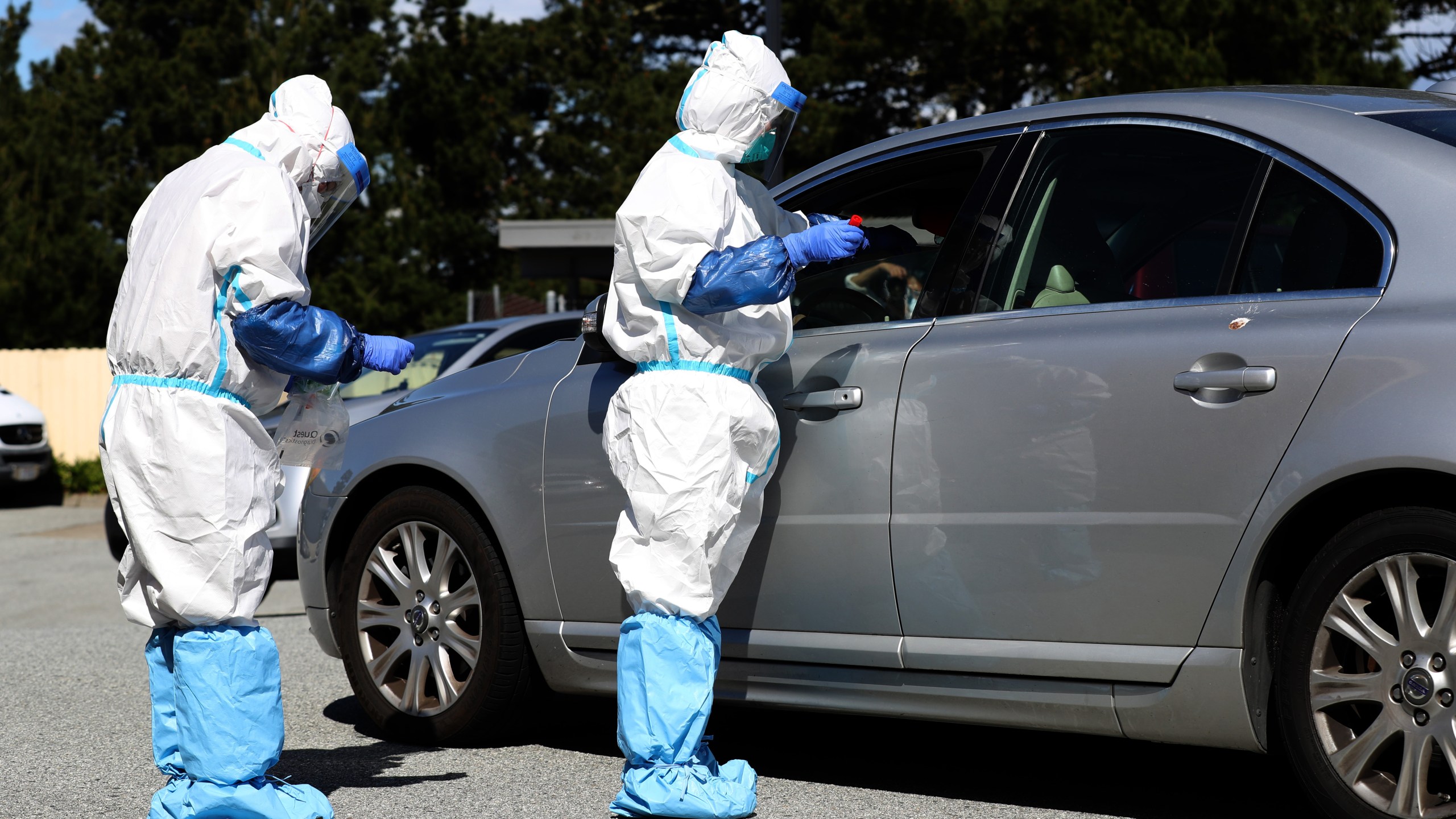 Medical professionals administer a coronavirus test during a drive-thru testing station on March 26, 2020 in Daly City. (Justin Sullivan/Getty Images)