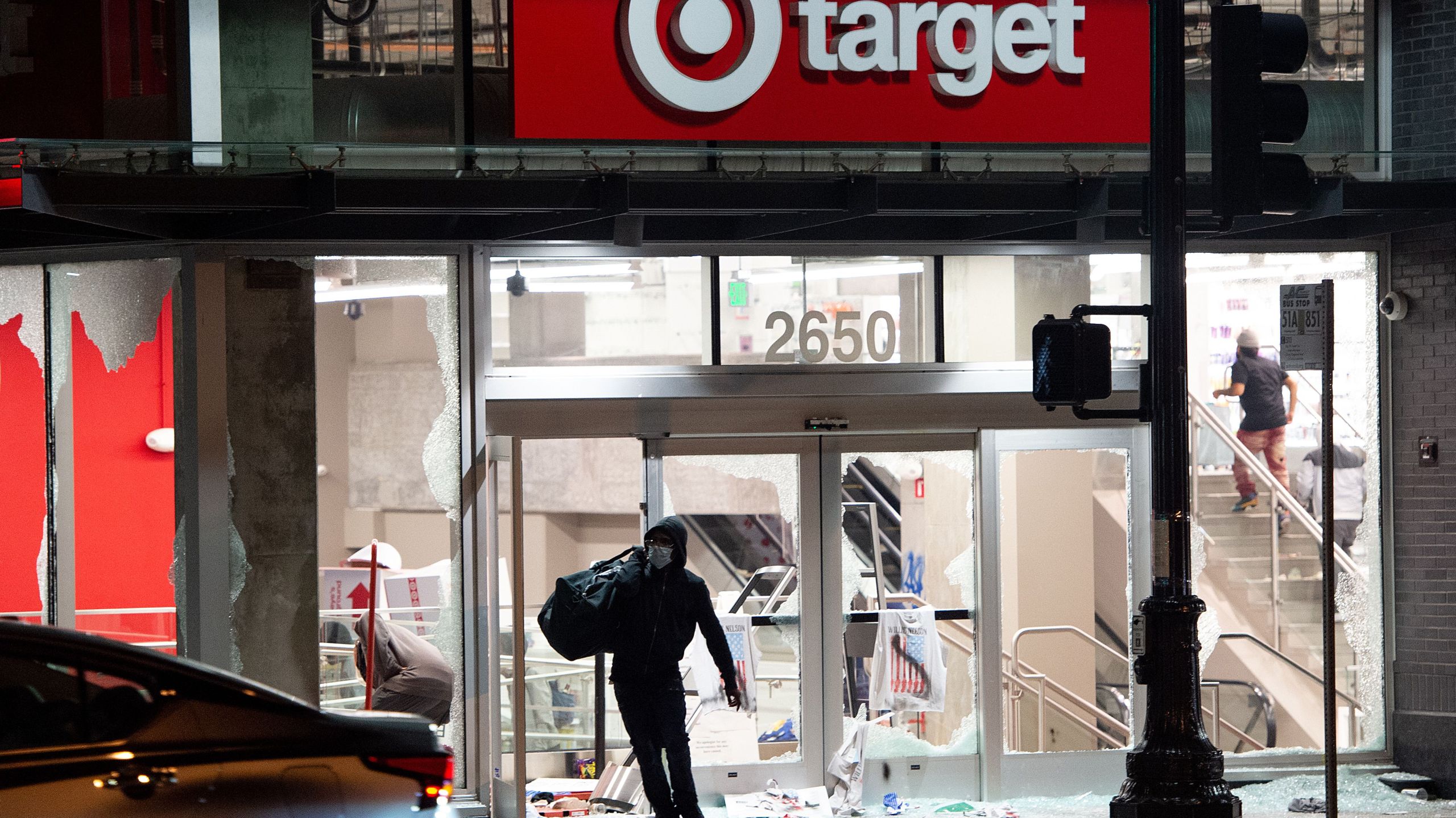 A looter steals items from a Target store as protesters face off with police in Oakland, Calif. on May 30, 2020. Protesters are rallying against police brutality nationwide following the death of George Floyd, a black man who died after a white policeman kneeled on his neck for several minutes. (JOSH EDELSON/AFP via Getty Images)