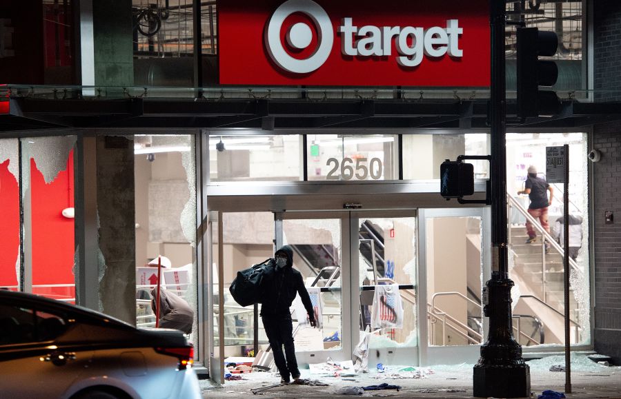 A looter steals items from a Target store as protesters face off with police in Oakland, Calif. on May 30, 2020. Protesters are rallying against police brutality nationwide following the death of George Floyd, a black man who died after a white policeman kneeled on his neck for several minutes. (JOSH EDELSON/AFP via Getty Images)