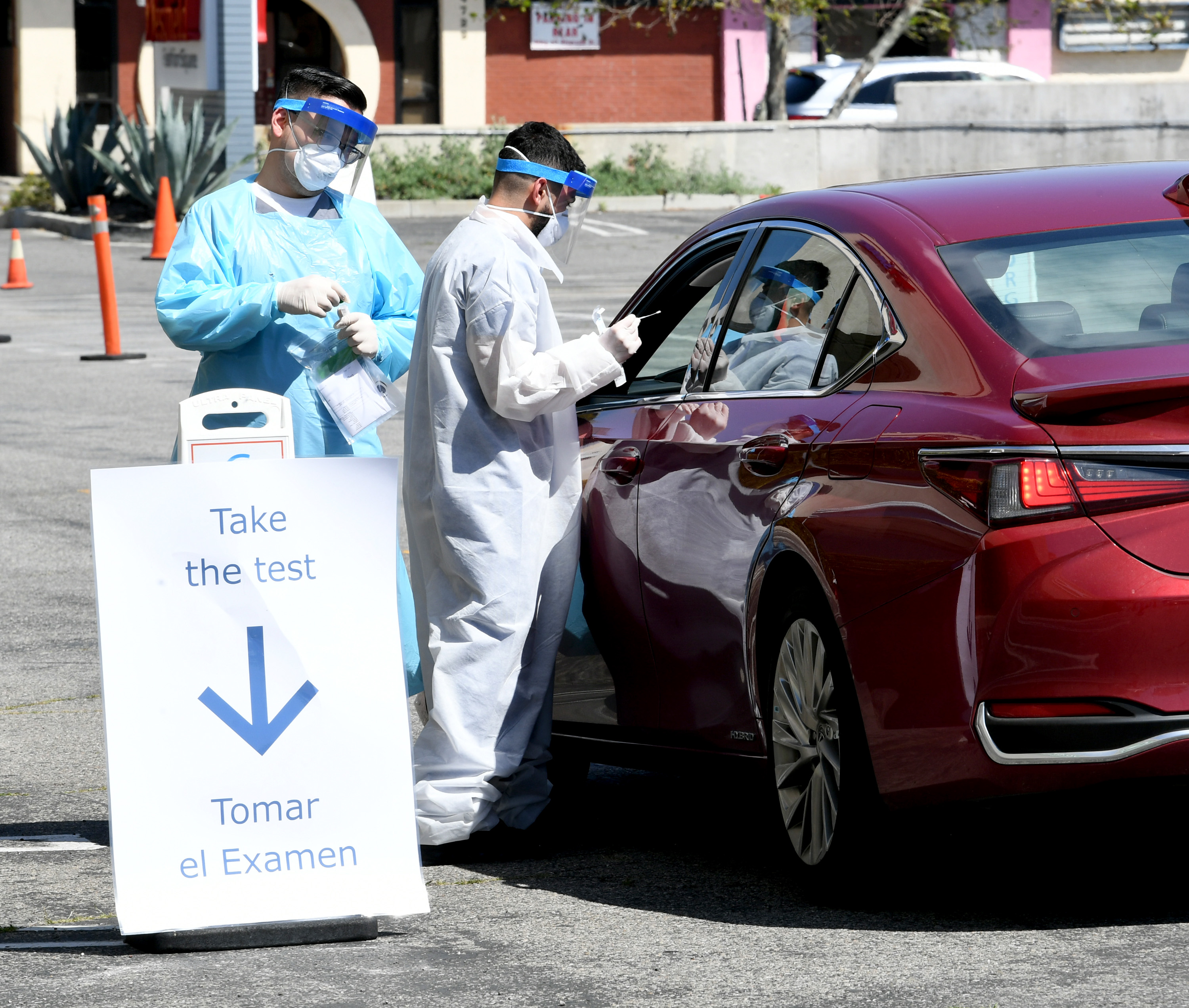 Workers wearing personal protective equipment (PPE) perform drive-up COVID-19 testing administered from a car at Mend Urgent Care testing site for the novel coronavirus at the Westfield Fashion Square on April 14, 2020 in the Sherman Oaks neighborhood of Los Angeles, California. (Kevin Winter/Getty Images)