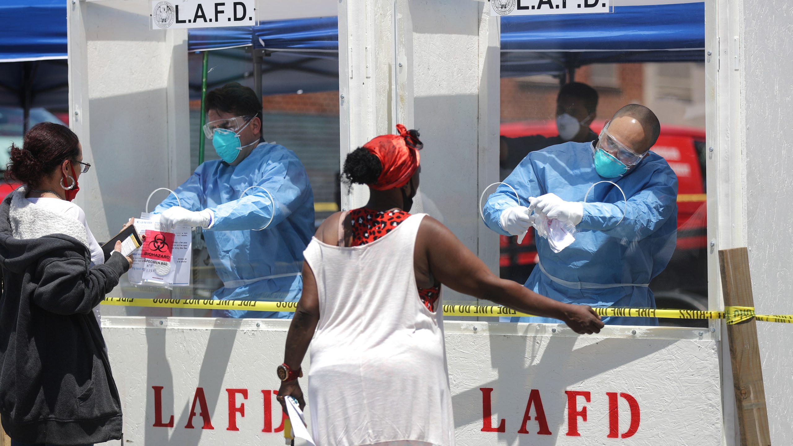 Women are tested for COVID-19 by members of the Los Angeles Fire Department wearing personal protective equipment in Skid Row amidst the coronavirus pandemic on April 21, 2020 in Los Angeles, California. Health officials reported that 43 people tested positive for COVID-19 at one Skid Row homeless shelter. (Mario Tama/Getty Images)