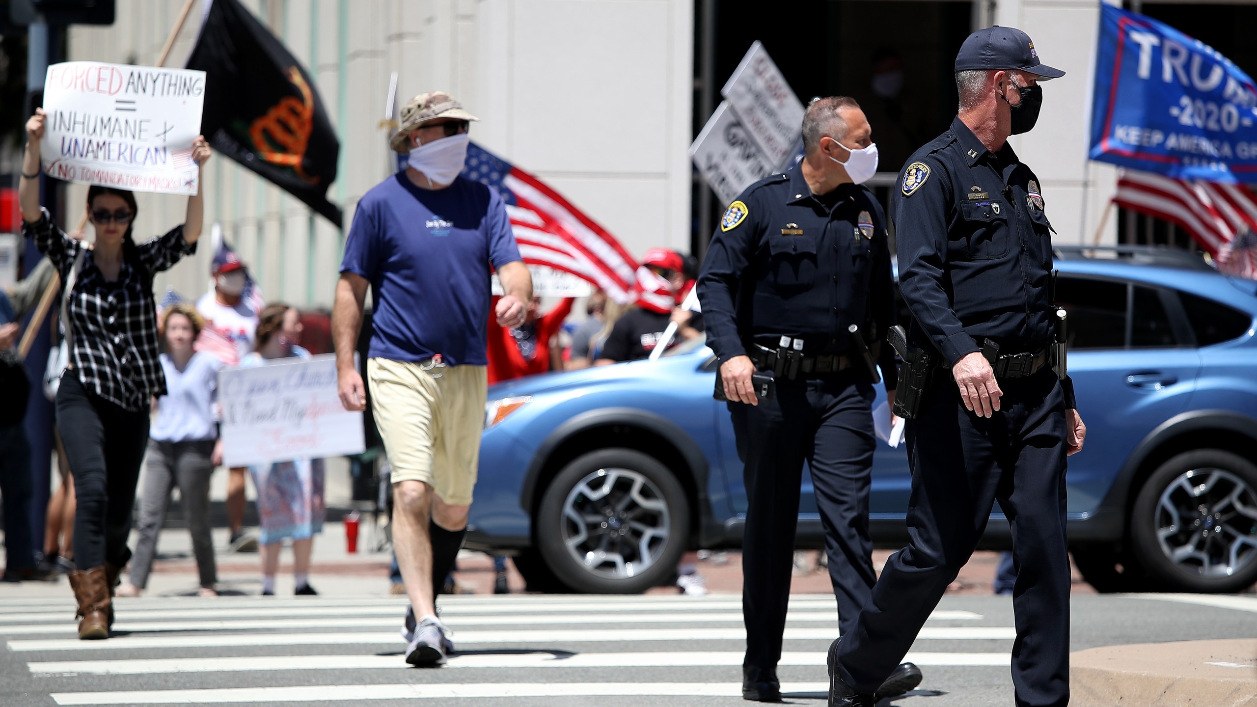 San Diego Police Department officers look on as activists hold signs and protest the California lockdown due to the coronavirus pandemic on May 1, 2020, in San Diego. (Sean M. Haffey/Getty Images)