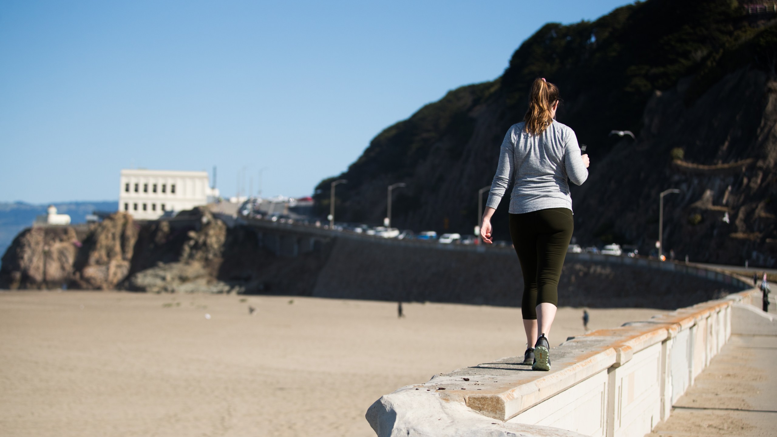 A woman walks on a beach path during the coronavirus pandemic on May 3, 2020 in San Francisco. (Rich Fury/Getty Images)