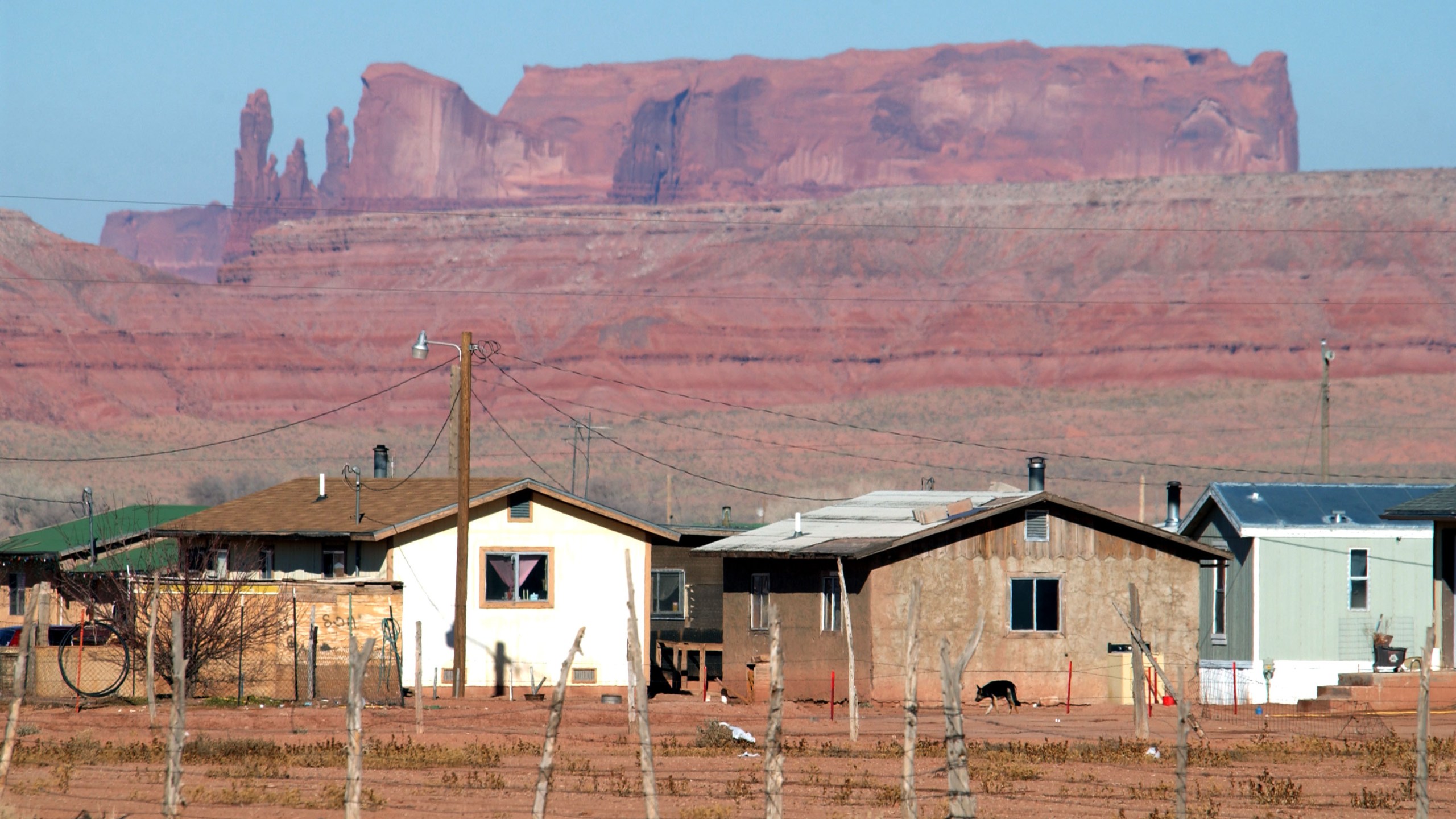 Houses are backed by sandstone cliffs on the Navajo Reservation in Arizona on Dec. 5, 2002. (David McNew/Getty Images)