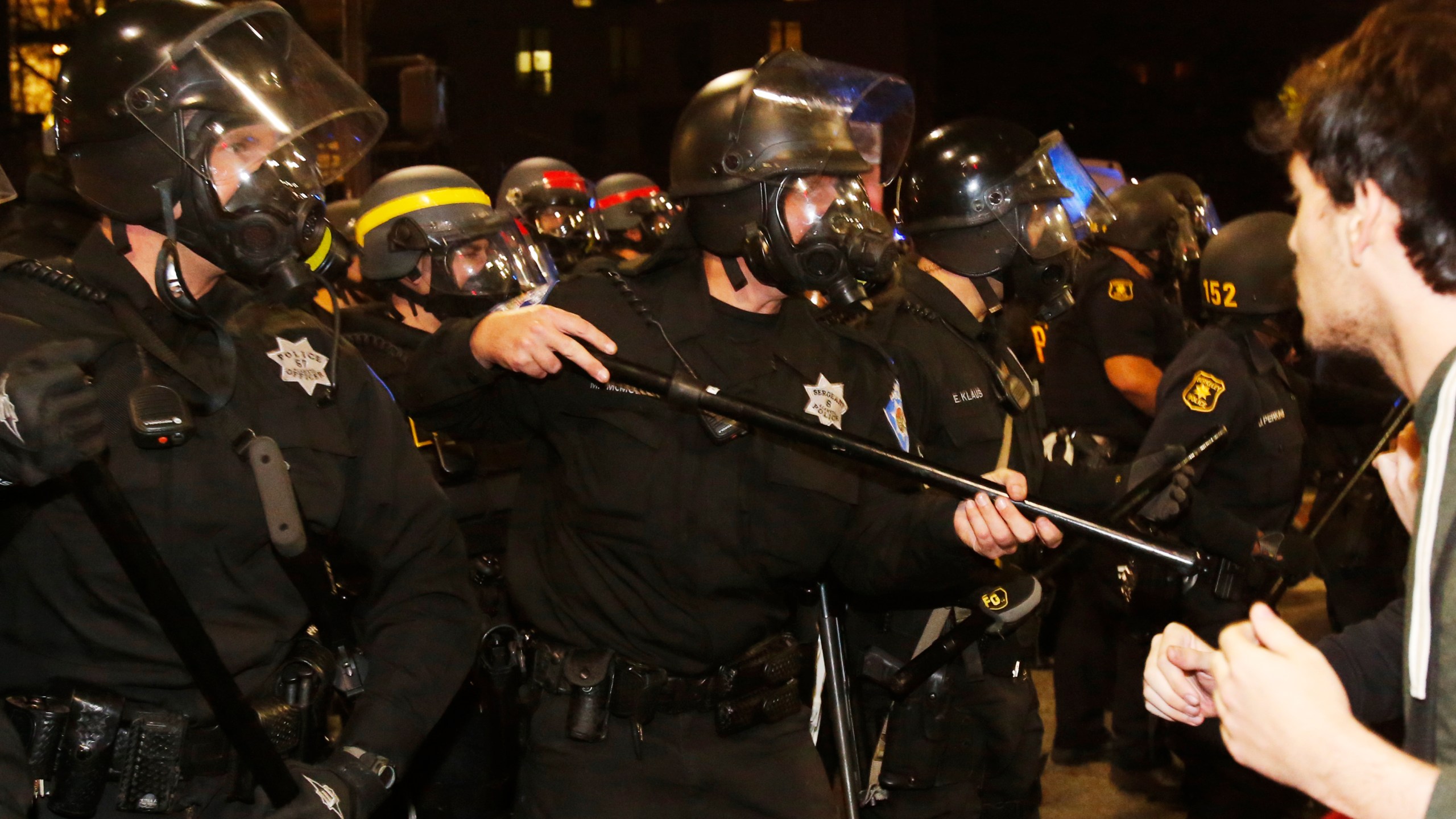 A row of police officers stand before protesters during a demonstration over recent grand jury decisions in police-involved deaths on Dec. 7, 2014, in Berkeley, Calif. A Staten Island, New York grand jury declined to indict New York City Police Officer Daniel Pantaleo in the chokehold death of Eric Garner. (Stephen Lam/Getty Images)