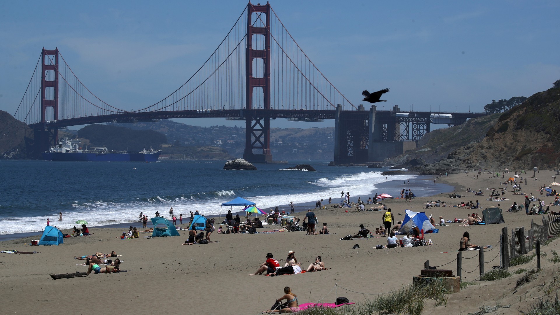 People sit on the beach at Baker Beach on May 26, 2020 in San Francisco, California. Beaches across the state have seen large crowds as they have started to slowly reopen with rules in place such as maintaining social distancing in order to slow the spread of COVID-19. (Justin Sullivan/Getty Images)