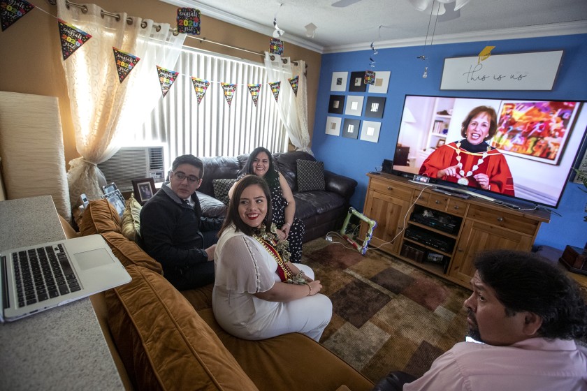 Maria Morales, center, a member of the USC Class of 2020, attends her virtual graduation via Zoom with her brother Manny Morales, left, mother Pilar Morales and stepdad Victor Ramos, right, in Orange.(Brian van der Brug / Los Angeles Times)