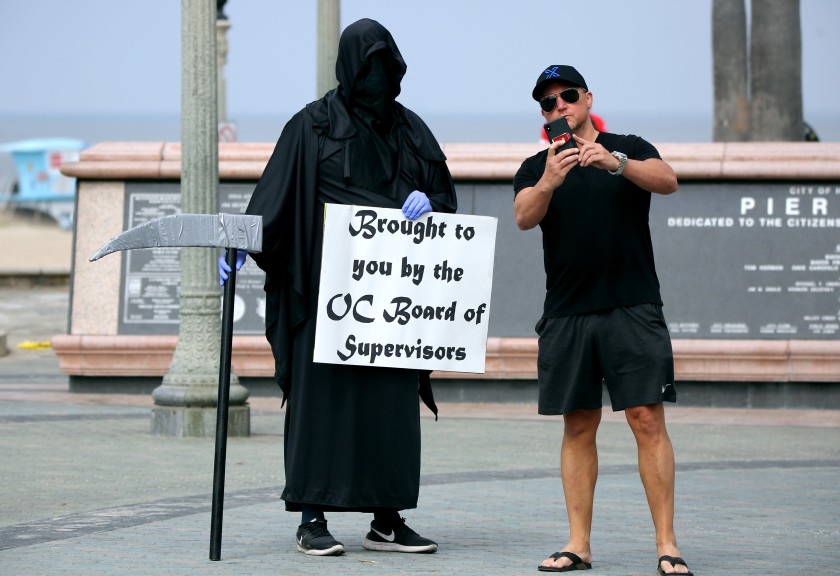 A man takes a selfie with the Grim Reaper, also known as Spencer Kelly of Huntington Beach, on May 8, 2020.(Raul Roa / Times Community News)