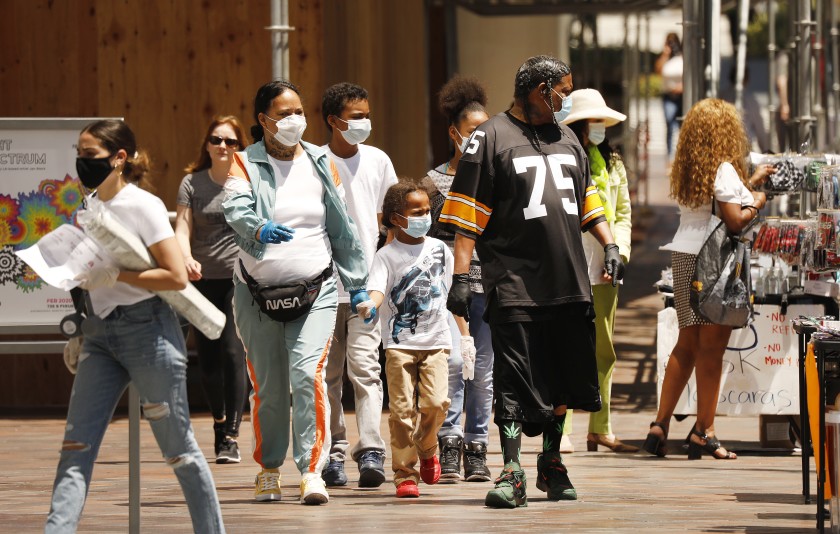 Families and friends shop Tuesday at Fig at 7th, an open-air shopping mall in downtown Los Angeles, which remains busy as the food court and several business are open.(Al Seib / Los Angeles Times)