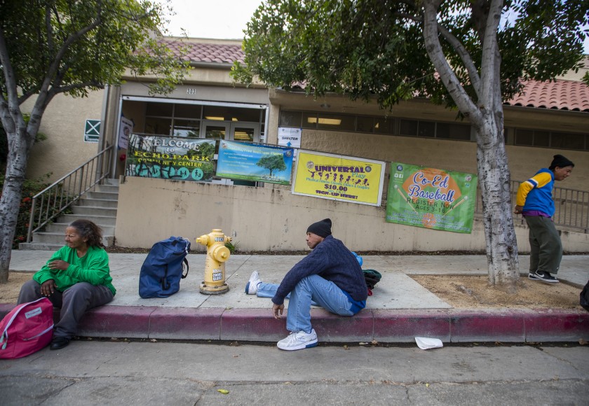 Tyrone Dixon, 53, center, waits with fellow homeless people outside the Echo Park Community Center, one of several Los Angeles recreation centers that have been converted to shelters during the COVID-19 pandemic. (Allen J. Schaben / Los Angeles Times)