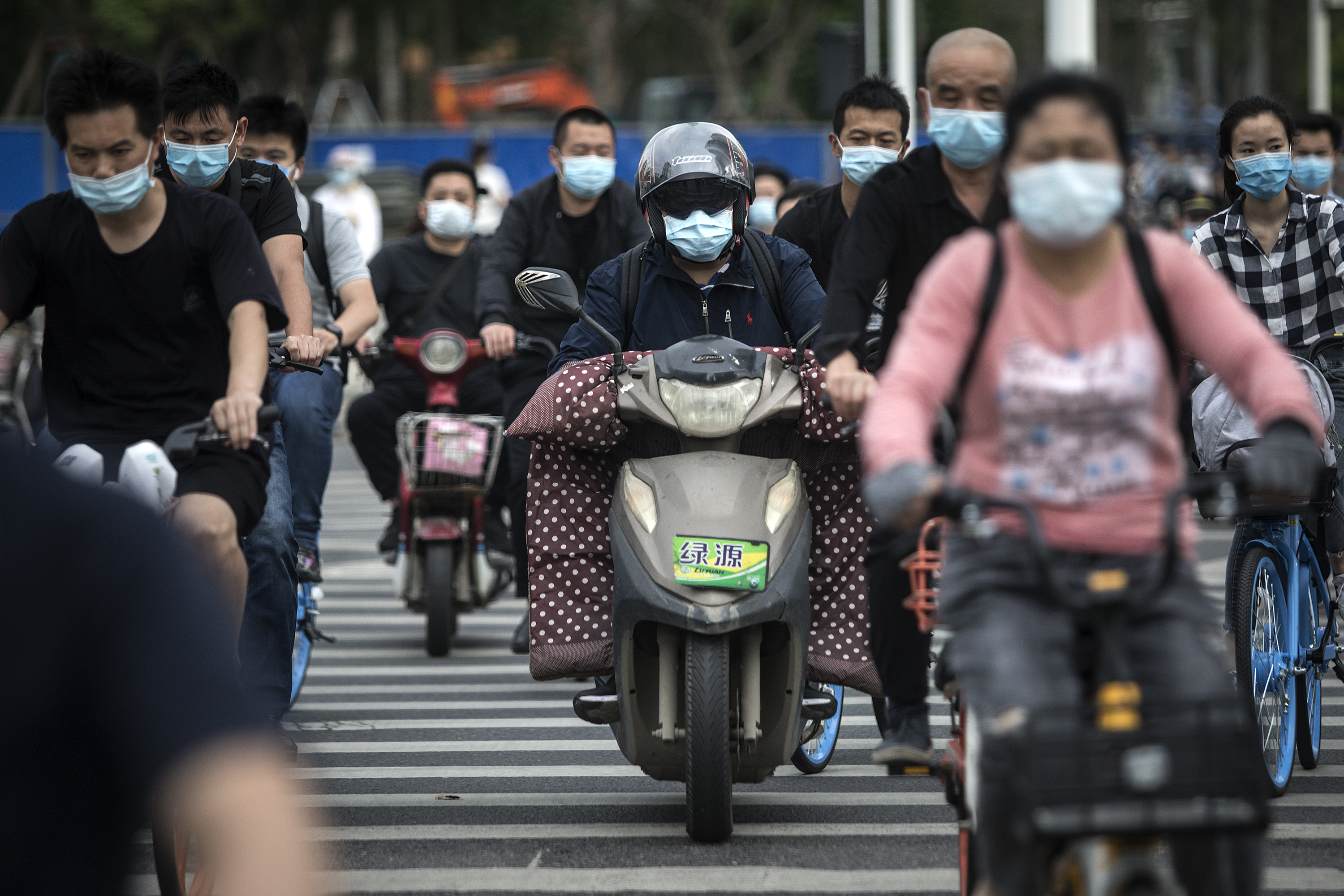 Residents wears face masks while riding their bicycles on May 11, 2020 in Wuhan, China. (Getty Images)