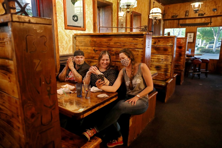 Jeremiah Pino and Lydia Perez, with server Aimee Roux, have their first night out in weeks May 5 at the Silver Dollar Saloon in Marysville. (Gary Coronado / Los Angeles Times)