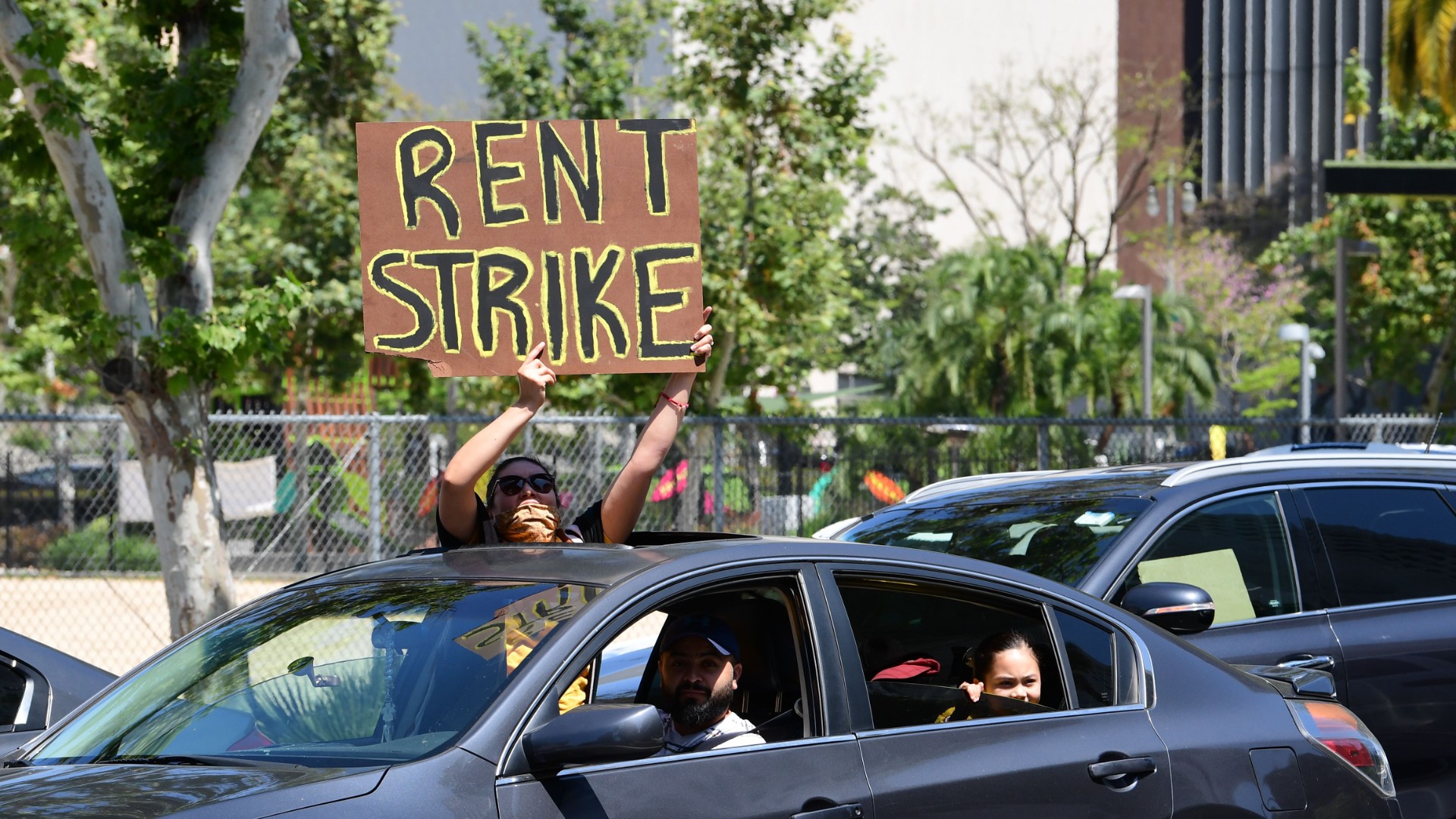 Demonstrators pass the Los Angeles City Hall on May 1, 2020, as they call for a rent strike during the coronavirus pandemic. (FREDERIC J. BROWN/AFP via Getty Images)