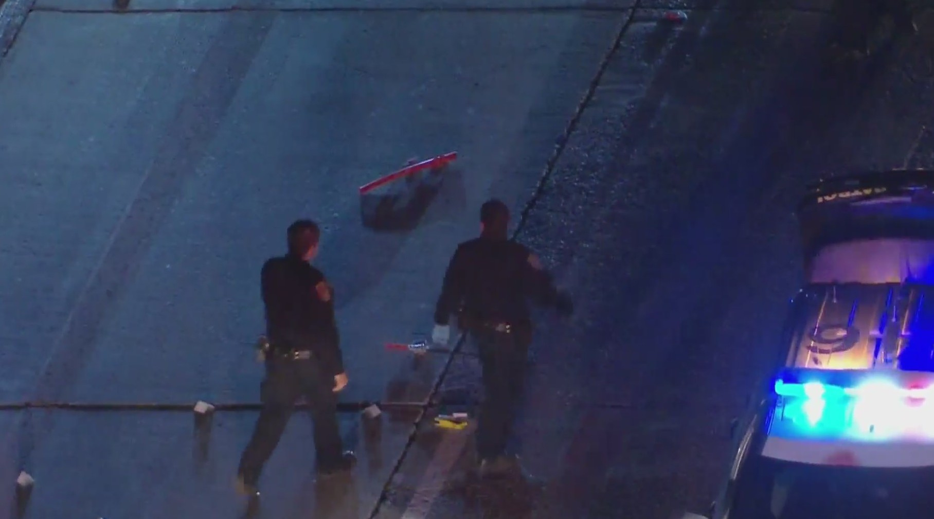 Officers walk by what appears to be a sheathed sword after a fatal shooting in Monterey Park on May 4, 2020. (KTLA)