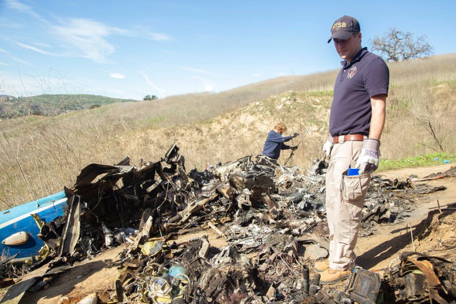 In this Jan. 27, 2020, file photo, provided by the National Transportation Safety Board, NTSB investigators Adam Huray, right, and Carol Hogan examine wreckage as part of the NTSB's investigation of a helicopter crash near Calabasas. (James Anderson/National Transportation Safety Board via AP, File)