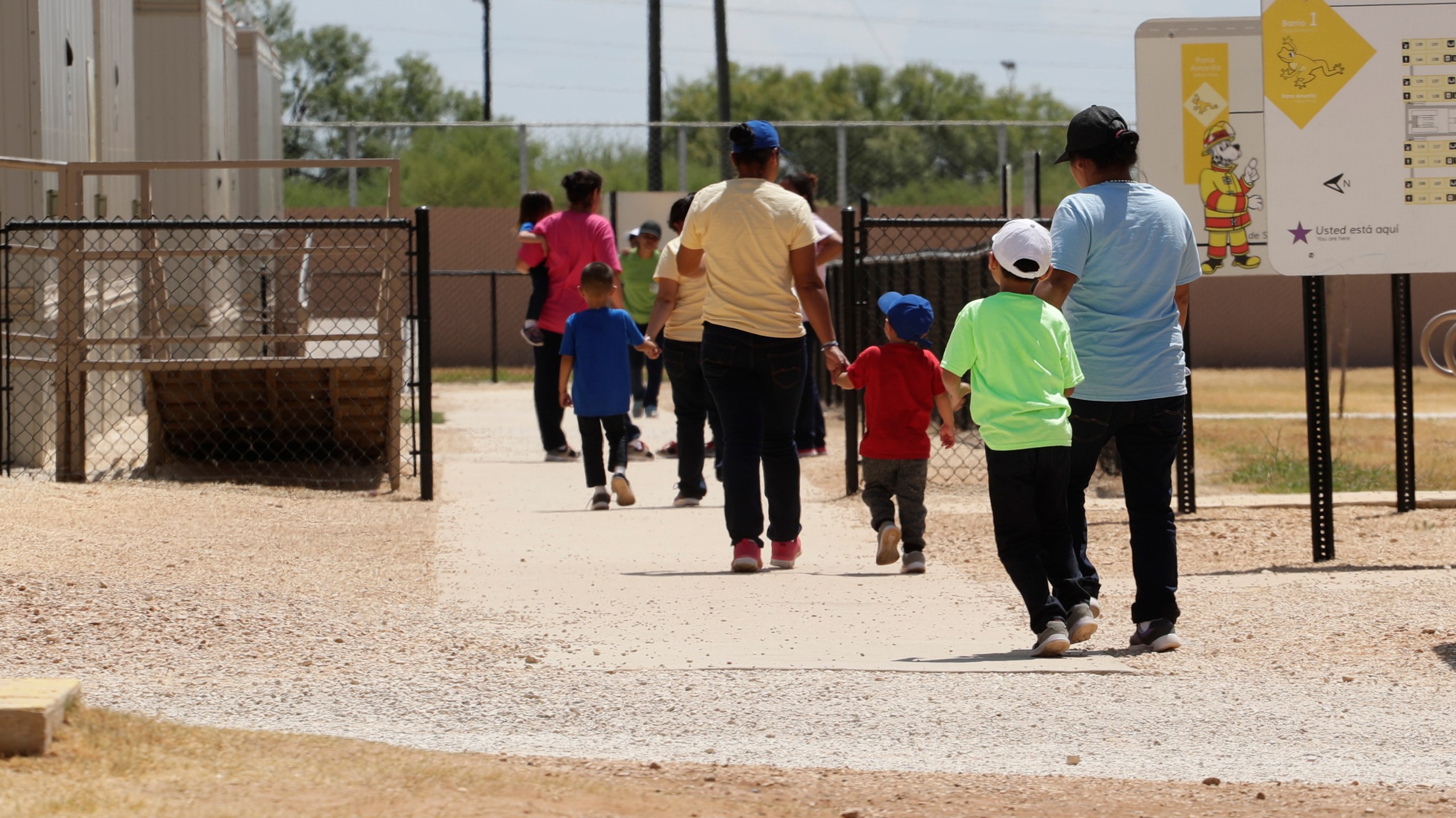 Immigrants seeking asylum hold hands as they leave a cafeteria at the ICE South Texas Family Residential Center in Dilley, Texas on Aug. 23, 2019. (AP Photo/Eric Gay, File)