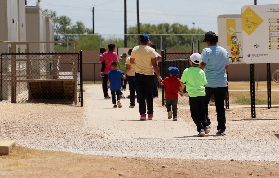 Immigrants seeking asylum hold hands as they leave a cafeteria at the ICE South Texas Family Residential Center in Dilley, Texas on Aug. 23, 2019. (AP Photo/Eric Gay, File)