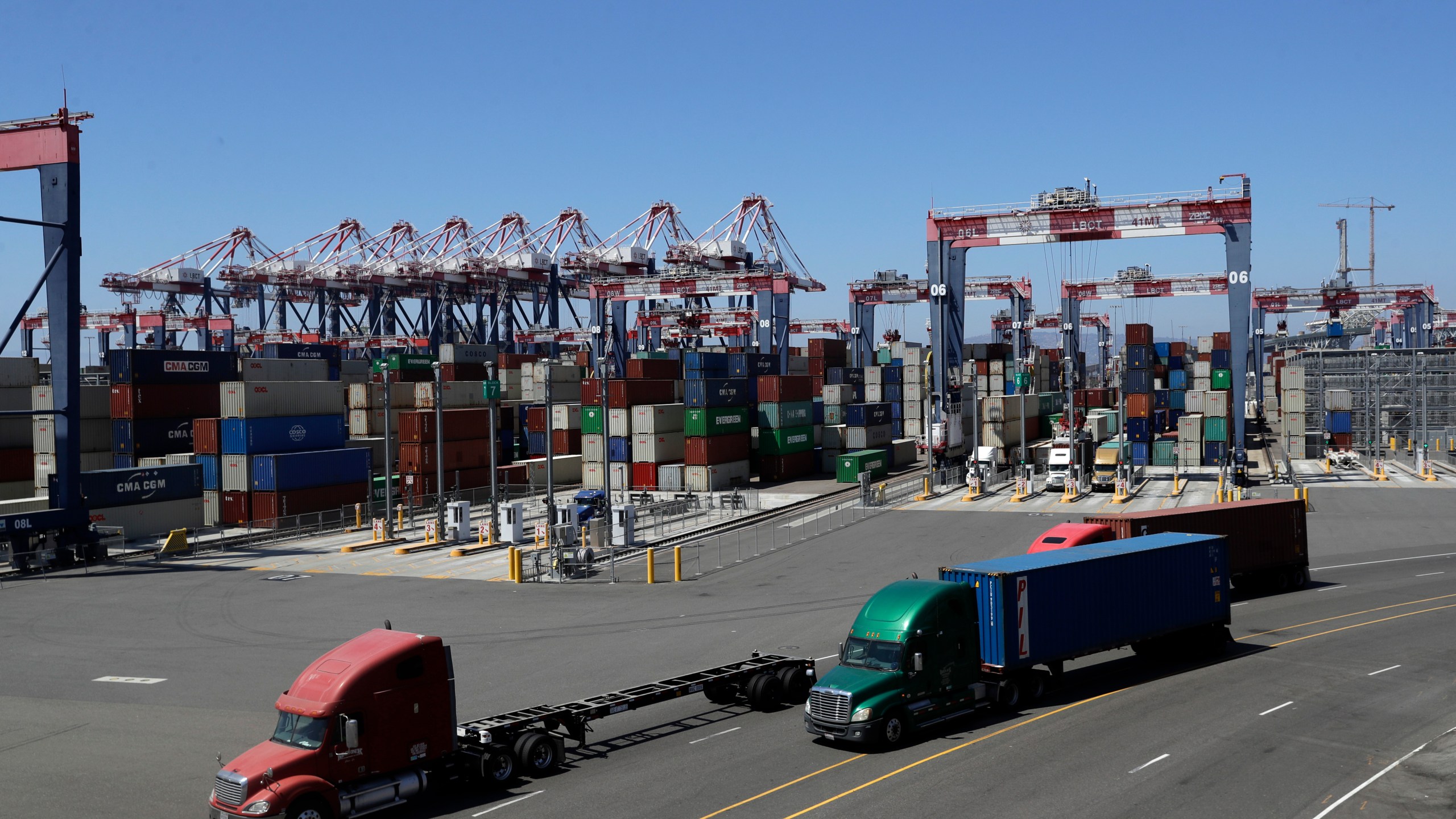 In this Aug. 22, 2018, file photo, trucks travel along a loading dock at the Port of Long Beach. (AP Photo / Marcio Jose Sanchez)