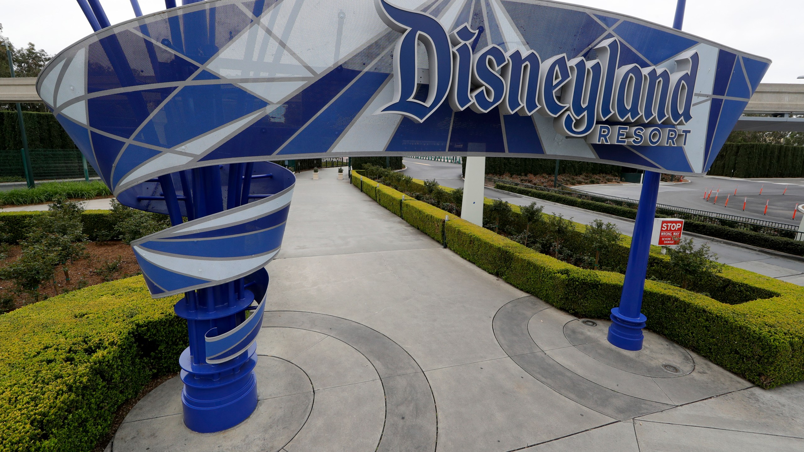 In this file photo taken Wednesday, March 18, 2020, one of the normally bustling entrances to the Disneyland resort is vacant due to the coronavirus closure in Anaheim, Calif. Disney is postponing the mid-July reopening of its Southern California theme parks until it receives guidelines from the state. (AP Photo/Chris Carlson,File)