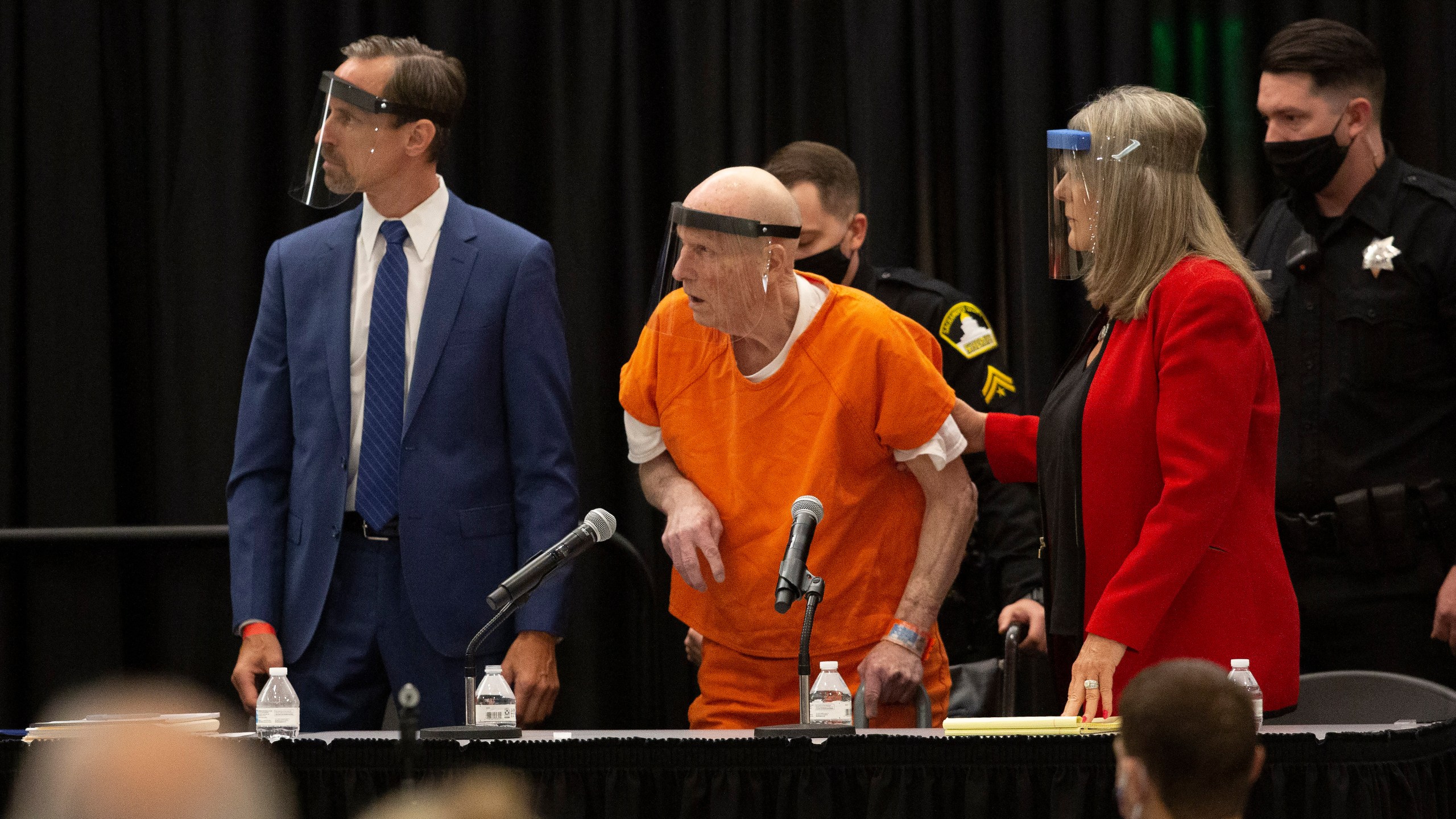 Joseph James DeAngelo, center, charged with being the Golden State Killer, his helped up by his attorney, Diane Howard, as Sacramento Superior Court Judge Michael Bowman enters the courtroom in Sacramento on June 29, 2020. (Rich Pedroncelli/Associated Press)