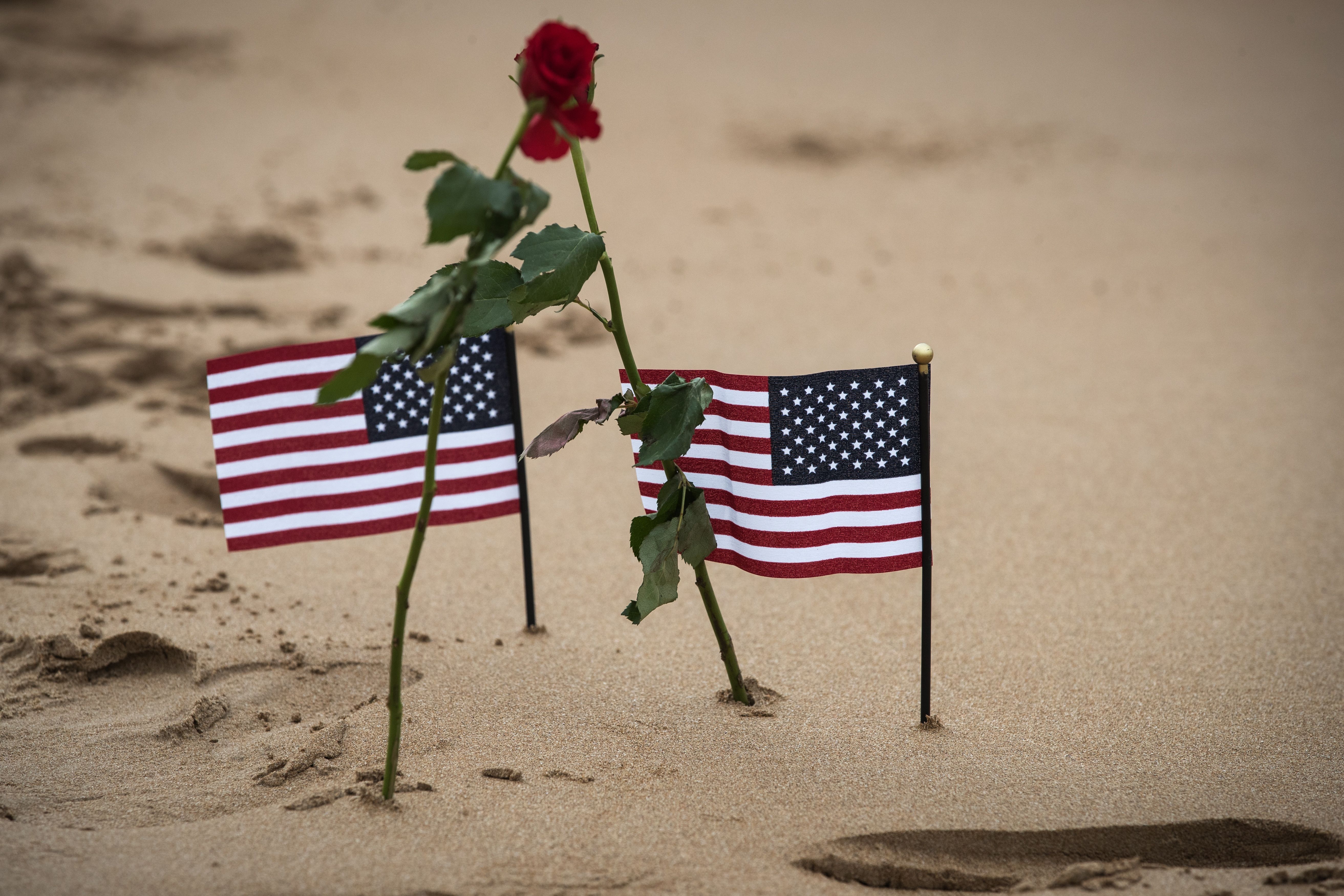 Two roses and two US flags are pictured on Omaha beach in Saint-Laurent-sur-Mer, Normandy, on June 5, 2019, on the sidelines of the D-Day commemorations marking the 75th anniversary of the World War II Allied landings in Normandy. (JOEL SAGET/AFP via Getty Images)