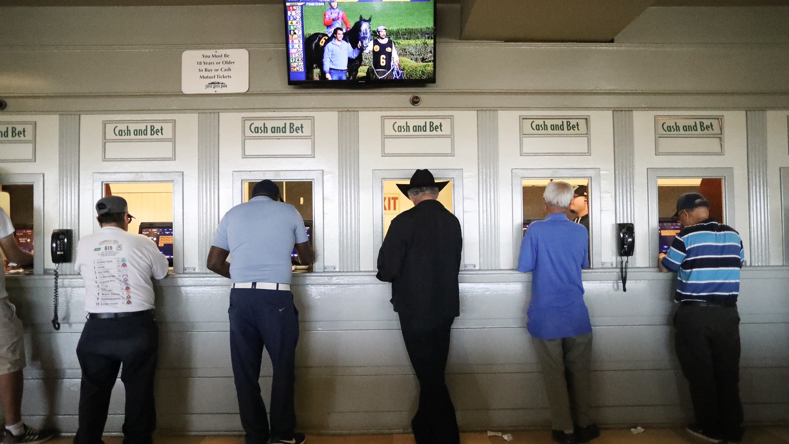 Gamblers stand at betting windows on the final day of the winter/spring horse racing season at Santa Anita Park on June 23, 2019, in Arcadia, California. (Mario Tama/Getty Images)