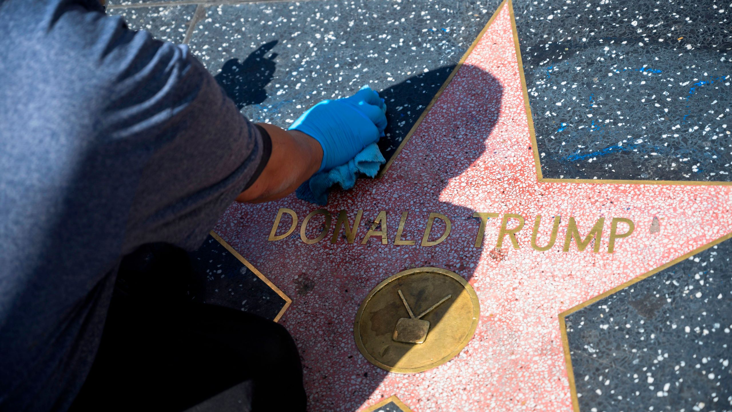 A maintenance worker uses cleaning product to remove graffiti after Donald Trump's star on the Hollywood Walk of Fame was defaced on April 23, 2020 (ROBYN BECK/AFP via Getty Images)