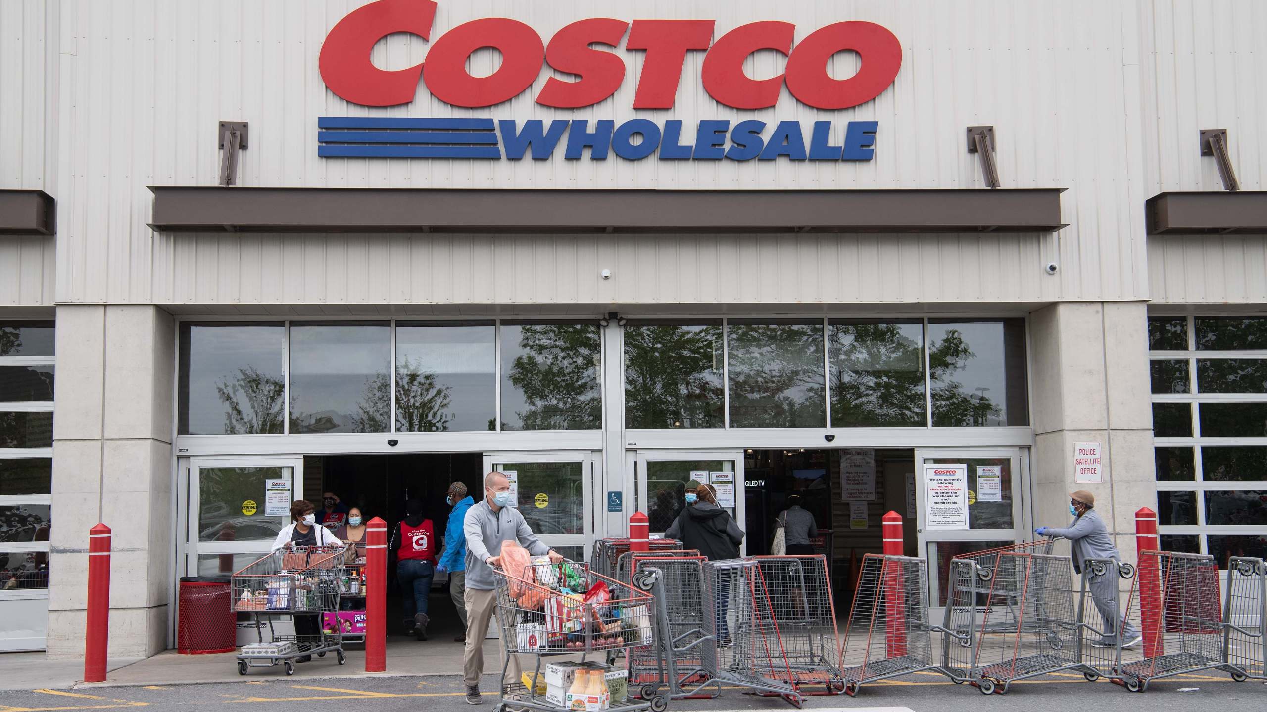 Shoppers walk out with full carts from a Costco store in Washington, DC, on May 5, 2020. (NICHOLAS KAMM/AFP via Getty Images)