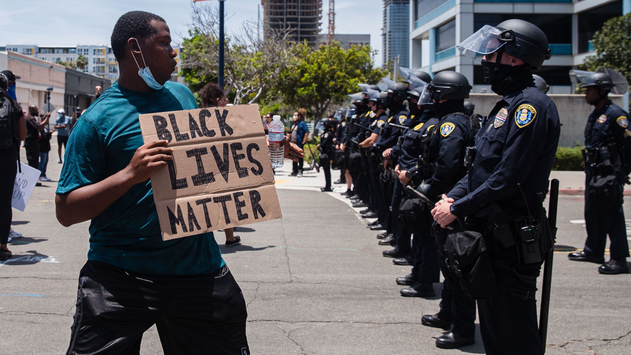 A man holds a Black Lives Matter sign in front of the San Diego Police in downtown San Diego, California on May 31, 2020, as they protest the death of George Floyd.(ARIANA DREHSLER/AFP via Getty Images)