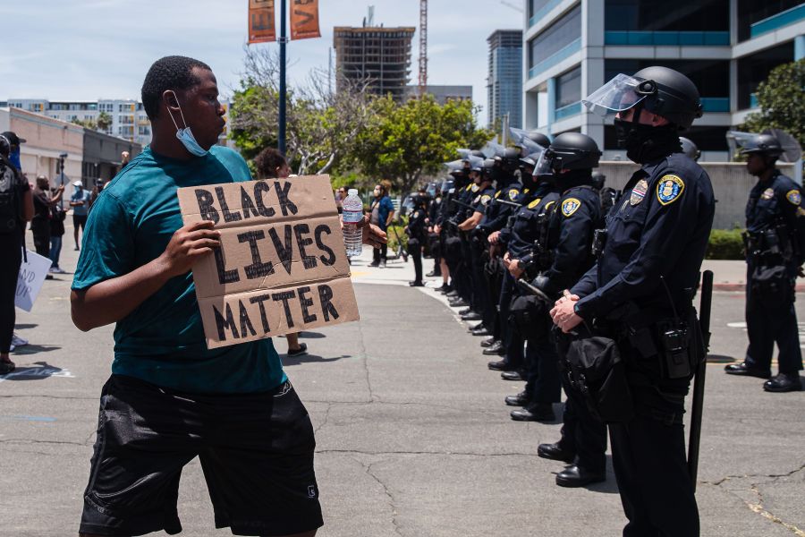 A man holds a Black Lives Matter sign in front of the San Diego Police in downtown San Diego, California on May 31, 2020, as they protest the death of George Floyd.(ARIANA DREHSLER/AFP via Getty Images)