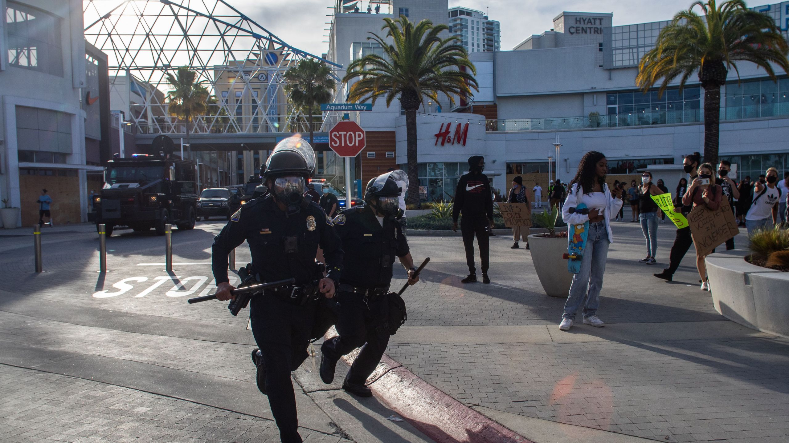 Police officers run in downtown Long Beach on May 31, 2020 during a protest against the death of George Floyd. (Apu GOMES / AFP) (Photo by APU GOMES/AFP via Getty Images)