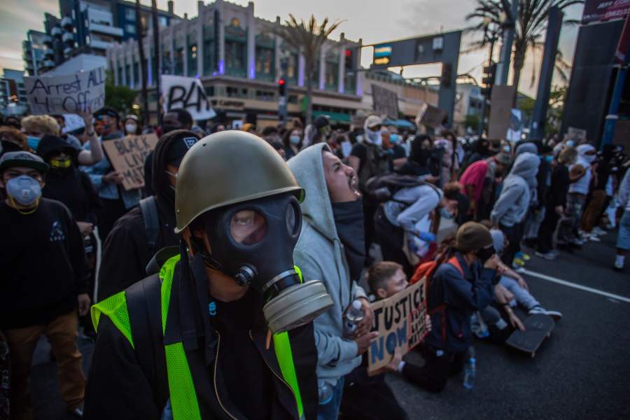 A man wearing a gas mask stands in front of a Police line in Downtown Long Beach on May 31, 2020, during a protest against the death of George Floyd. (APU GOMES/AFP via Getty Images)