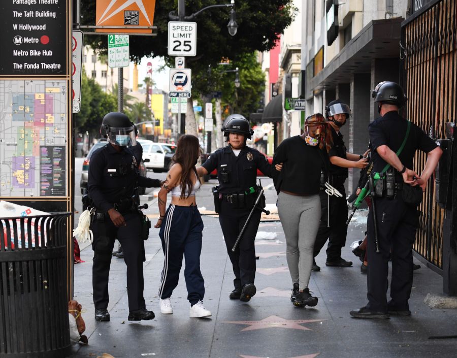 Police officers arrest people after a store was looted in Hollywood on June 1, 2020, after a third day of protests and looting throughout California. (ROBYN BECK/AFP via Getty Images)