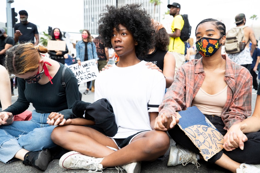 Demonstrators sit holding hands during a march on June 2, 2020 in Los Angeles. (Brent Stirton/Getty Images)