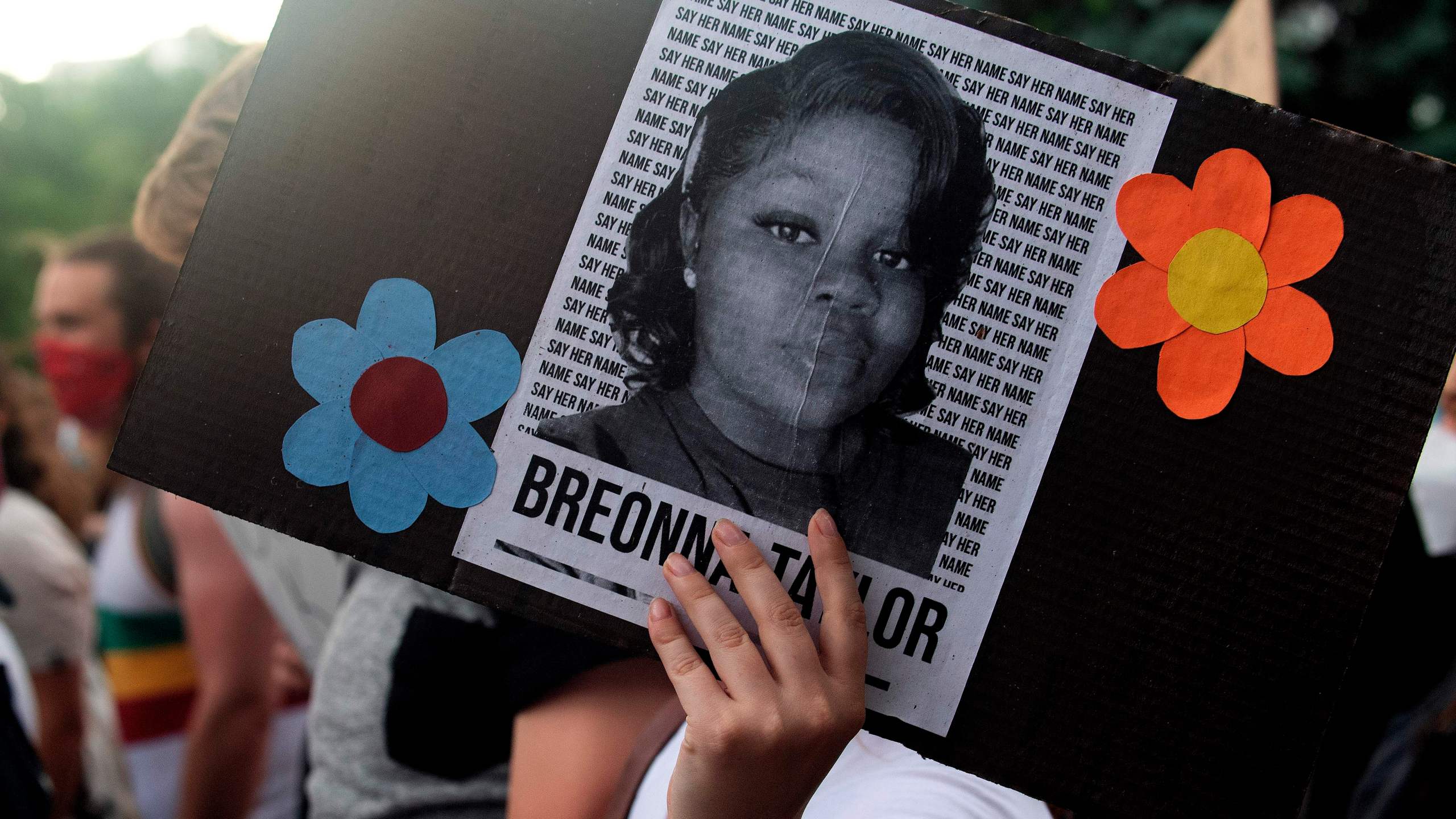 A demonstrator holds a sign with the image of Breonna Taylor, a black woman who was fatally shot by Louisville Metro Police Department officers, during a protest against the death George Floyd in Denver, Colorado on June 3, 2020. JASON CONNOLLY/AFP via Getty Images)